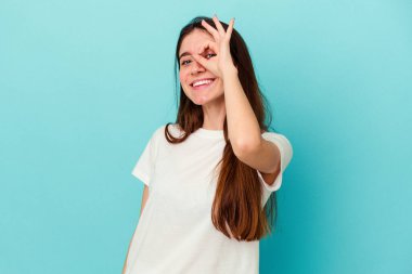 Kafkasyalı genç bir kadın mavi arka planda izole edilmiş. Heyecanlı..