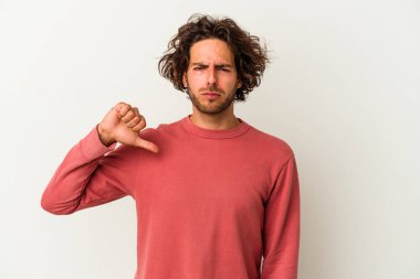 Beyaz arka planda izole edilmiş genç beyaz adam baş parmağını aşağı gösteriyor, hayal kırıklığı konsepti..