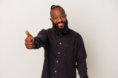 Pembe arka planda sakallı Afrikalı Amerikalı adam gülümsüyor ve başparmağını kaldırıyor.