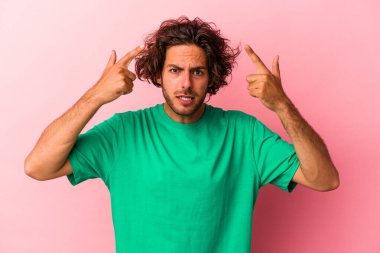 Pembe fırında izole edilmiş genç beyaz adam işaret parmağıyla hayal kırıklığı jesti yapıyor..
