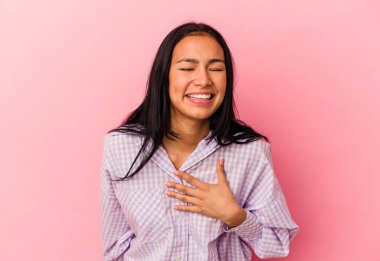 Genç Venezuelalı bir kadın pembe arka planda izole edilmiş..