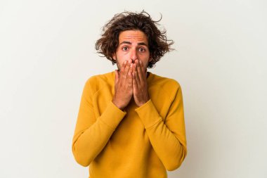 Beyaz arka planda izole edilmiş genç beyaz bir adam ağzı kapalı ve elleri endişeli görünüyor..
