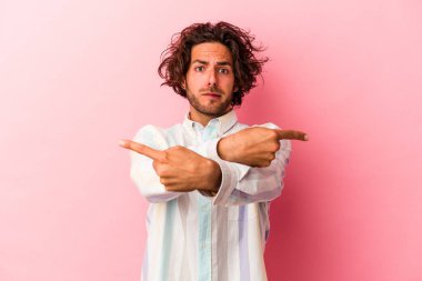 Pembe bakkal noktalarında izole edilmiş genç beyaz adam iki seçenek arasında seçim yapmaya çalışıyor..