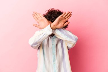 Pembe fırında izole edilmiş genç beyaz adam iki kolu çapraz tutuyor, inkar kavramı..