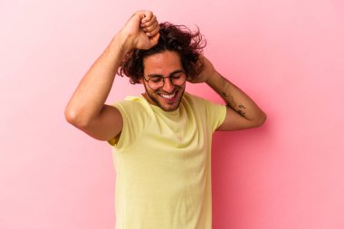 Pembe fırında özel bir günü kutlayan beyaz bir adam atlıyor ve enerjiyle kollarını kaldırıyor..