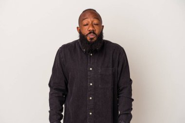 Pembe arka planda sakallı Afrikalı Amerikalı bir adam omuz silkiyor ve gözleri açık..