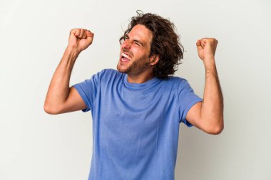Beyaz arka planda izole edilmiş genç beyaz bir adam zaferden sonra yumruğunu kaldırıyor, kazanan konsept.