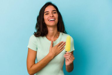 Mavi arka planda izole edilmiş dondurma tutan beyaz bir kadın mavi arka planda izole edilmiş bir dondurma tutan beyaz bir kadın kahkahalar atıyor..