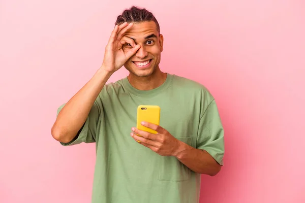 Młody Wenezuelczyk Trzyma Telefon Komórkowy Odizolowany Różowym Tle Podekscytowany Trzymając — Zdjęcie stockowe