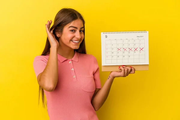 Giovane Donna Caucasica Possesso Calendario Isolato Sfondo Giallo Cercando Ascoltare — Foto Stock