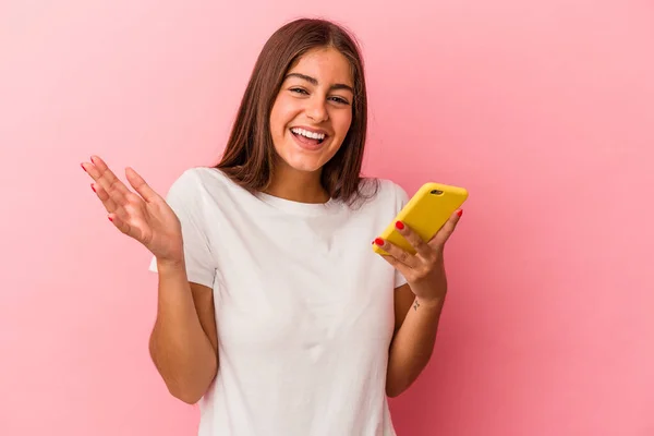 분홍색 배경에 고립된 핸드폰을 코카서스 여성은 놀랍고 흥분되어 즐거운 소리를 — 스톡 사진