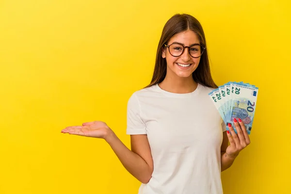 Young Caucasian Woman Holding Bills Isolated Yellow Background Showing Copy — Stock Photo, Image