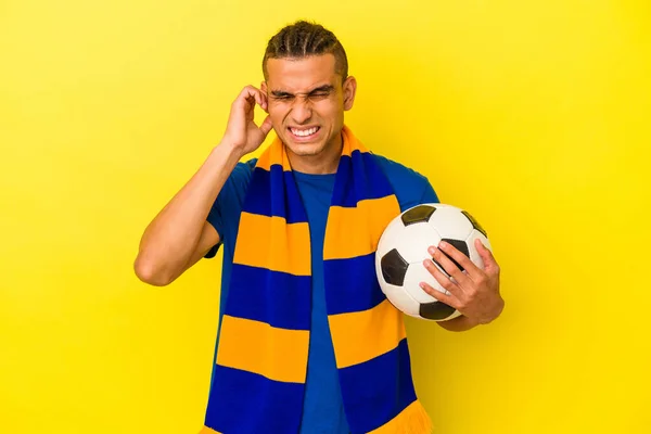 Joven Venezolano Observando Fútbol Aislado Sobre Fondo Amarillo Cubriendo Orejas —  Fotos de Stock