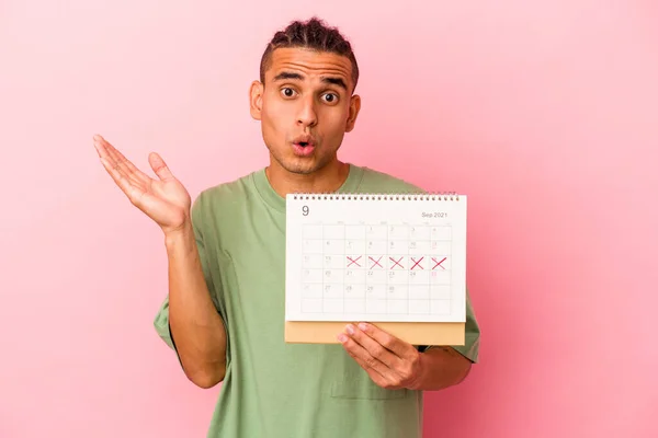 Joven Venezolano Sosteniendo Calendario Aislado Sobre Fondo Rosa Sorprendido Sorprendido — Foto de Stock