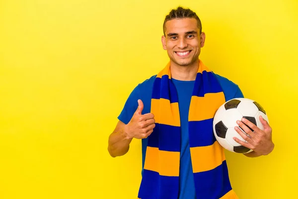 Jogador de futebol forte com bola de futebol e sorrindo em fundo branco  isolado