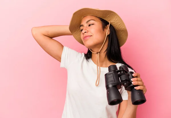 Junge Mischlingsforscherin Mit Fernglas Auf Rosa Hintergrund Berührt Hinterkopf Denkt — Stockfoto