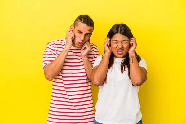 Sarı Arka Planda Izole Edilmiş Genç Latin Çift Kulaklarını Elleriyle — Stok fotoğraf