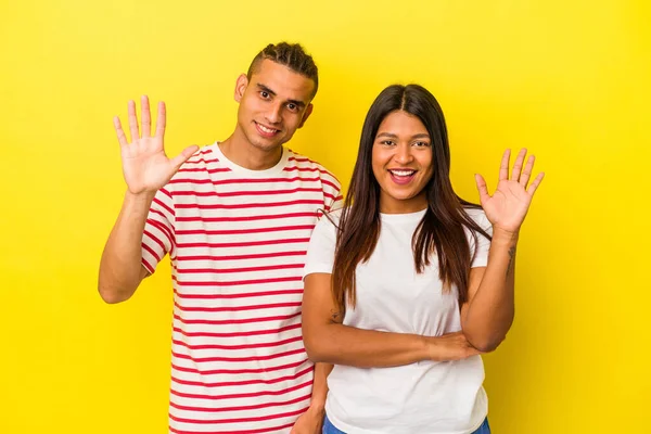 Jong Latijn Paar Geïsoleerd Gele Achtergrond Lachend Vrolijk Tonen Nummer — Stockfoto