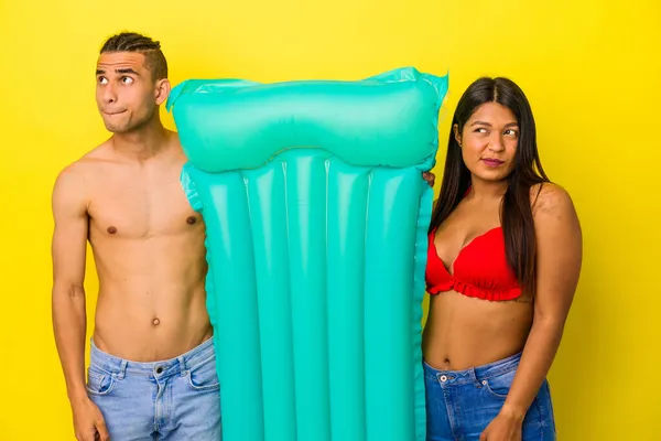 Jovem Casal Latino Segurando Colchão Isolado Fundo Amarelo Confuso Sente — Fotografia de Stock