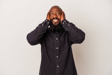 Pembe arka planda sakallı Afro-Amerikan bir adam ellerini başının üstünde tutarak gülüyor. Mutluluk kavramı.