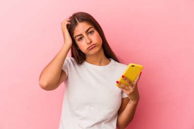 Pembe arka planda cep telefonu tutan genç beyaz kadın şok geçiriyordu. Önemli bir toplantıyı hatırladı..