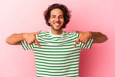 Kafkasyalı genç adam pembe bakkal sahasında izole edilmiş parmaklarıyla aşağıya bakıyor, olumlu bir his..