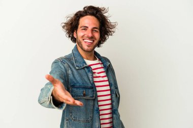 Beyaz arka planda izole edilmiş genç beyaz bir adam selamlama jesti olarak kameraya elini uzatıyor..