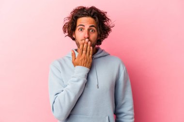 Pembe fırında izole edilmiş genç beyaz adam şok olmuş, ağzı ellerle kaplanmış, yeni bir şey keşfetmek için sabırsızlanıyor..