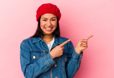 Genç Venezuelalı bir kadın pembe arka planda izole edilmiş..