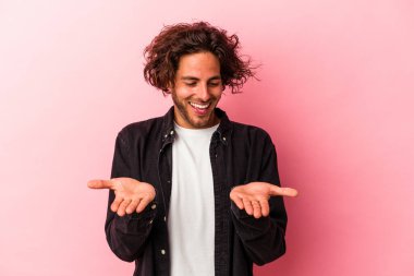 Kafkasyalı genç bir adam pembe fırında izole edilmiş. Elinde avuç içi olan bir şeyle kameraya sunuyor..