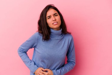 Pembe arka planda karaciğer ağrısı çeken, karnı ağrıyan beyaz bir kadın..