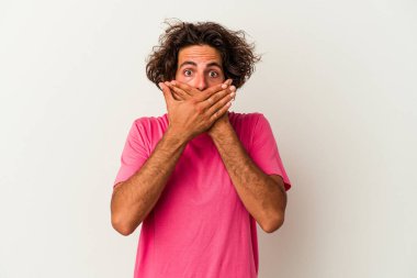 Beyaz arka planda izole edilmiş genç beyaz bir adam ağzı kapalı ve elleri endişeli görünüyor..