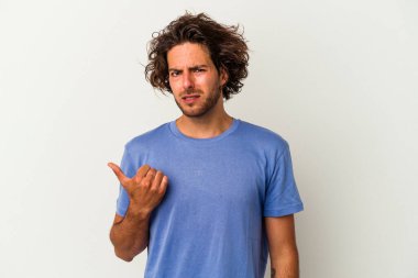 Beyaz arka planda izole edilmiş genç beyaz bir adam işaret parmağıyla fotokopi alanını işaret ederek şok oldu..