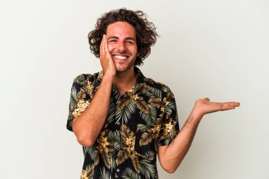 Beyaz arka planda izole edilmiş genç beyaz bir adam bir avuç içinde fotokopi alanı tutuyor, el üstünde tutuyor. Şaşırmış ve mutlu..