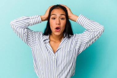 Genç Venezuelalı kadın mavi arka planda izole edilmiş şaşırmış ve şok olmuş..
