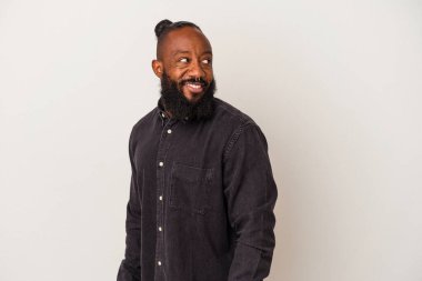 Pembe arka planda sakallı Afrikalı Amerikalı adam gülümsüyor, neşeli ve keyifli görünüyor..