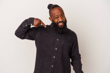 Pembe arka planda sakallı Afro-Amerikan bir adam gömleğin fotokopi odasını gösteriyor, gururlu ve kendinden emin.