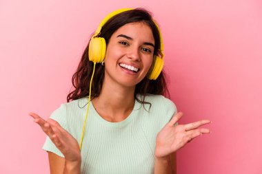 Pembe arka planda müzik dinleyen beyaz bir kadın hoş bir sürprizle karşılaşıyor, heyecanlı ve el kaldırıyor..