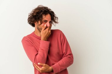 Beyaz arka planda izole olmuş genç beyaz bir adam gülüyor, kaygısız, doğal bir duygu..