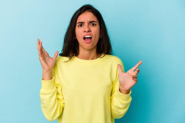 Mavi arka planda izole edilmiş beyaz bir kadın öfkeyle bağırıyor..