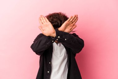 Pembe fırında izole edilmiş genç beyaz adam iki kolu çapraz tutuyor, inkar kavramı..