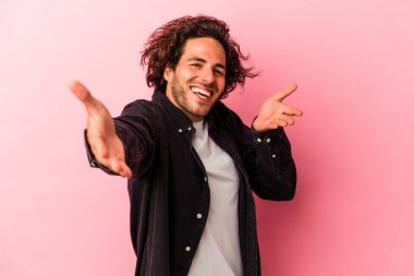 Pembe fırında izole edilmiş genç beyaz adam kameraya sarıldığı için kendinden emin..