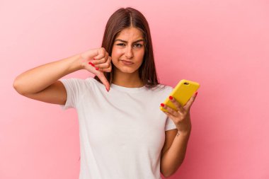 Pembe arka planda izole edilmiş cep telefonu tutan beyaz bir kadın hoşlanmadığı bir hareket gösteriyor. Anlaşmazlık konsepti.