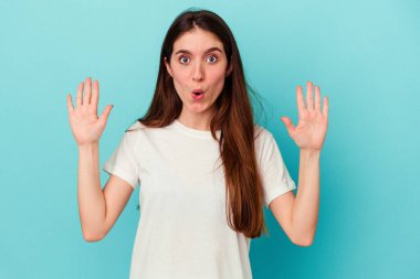 Kafkasyalı genç bir kadın mavi arka planda izole edilmiş. Bir fikri var, ilham verici bir kavram..