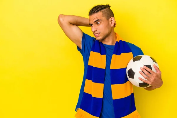 Joven Venezolano Observando Fútbol Aislado Sobre Fondo Amarillo Tocando Parte —  Fotos de Stock