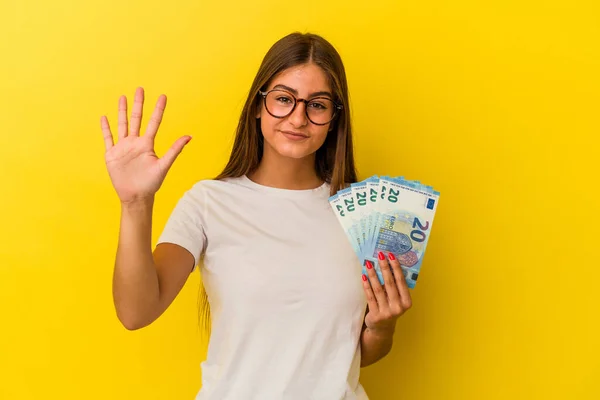 Mladá Běloška Drží Bankovky Izolované Žlutém Pozadí Veselým Úsměvem Ukazující — Stock fotografie