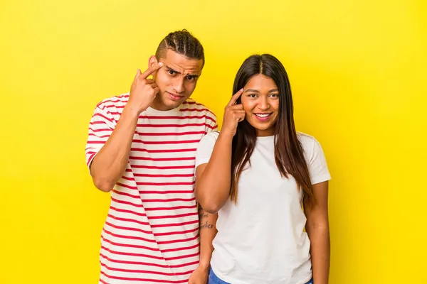 Sarı Arka Planda Izole Edilmiş Genç Latin Çift Işaret Parmağıyla — Stok fotoğraf