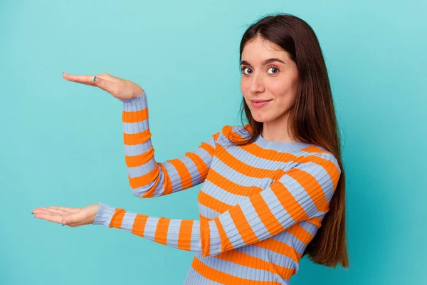 Junge Kaukasische Frau Isoliert Auf Blauem Hintergrund Hält Etwas Mit — Stockfoto