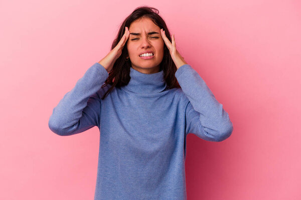 Young caucasian woman isolated on pink background touching temples and having headache.