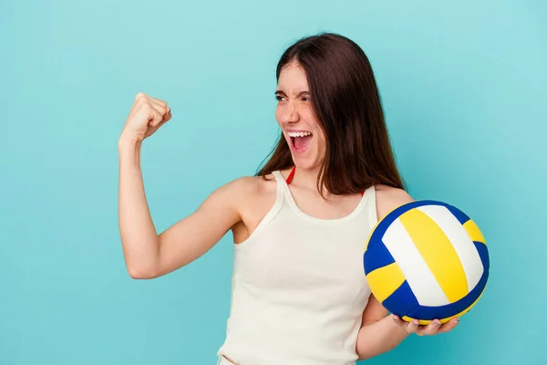 Молода Біла Жінка Грає Волейбол Ізольовано Синьому Фоні Піднімаючи Кулак — стокове фото